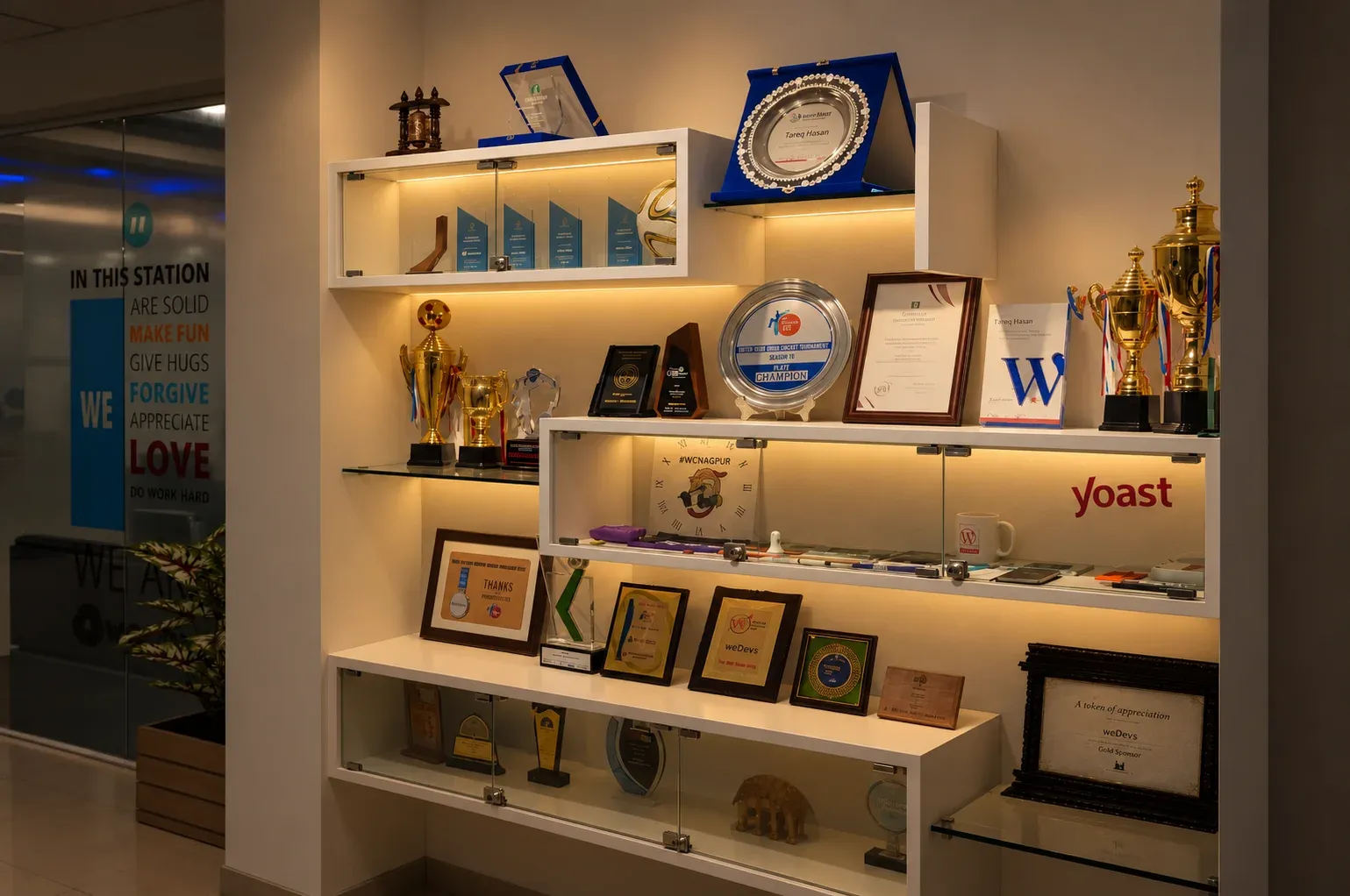 Awards and trophies on a lit shelf at the weDevs office